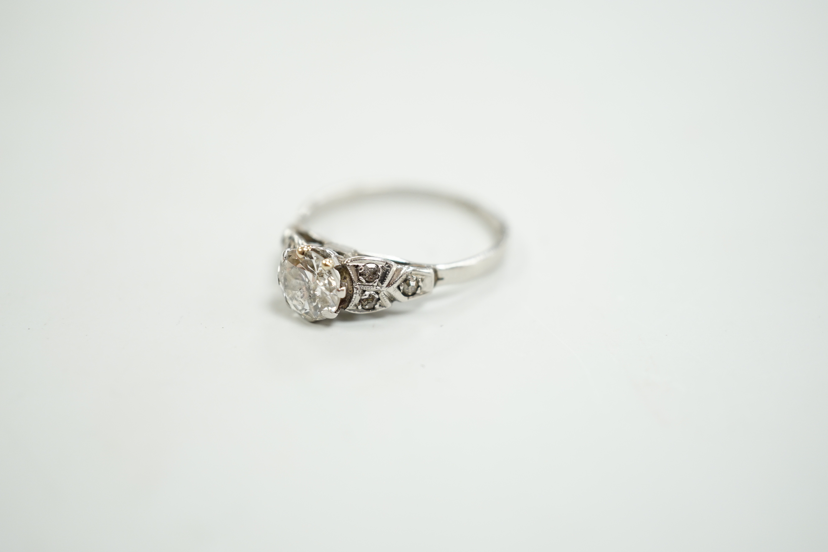 A white metal, stamped plat and single stone diamond ring, with diamond set shoulders, size O, gross weight 3.2 grams